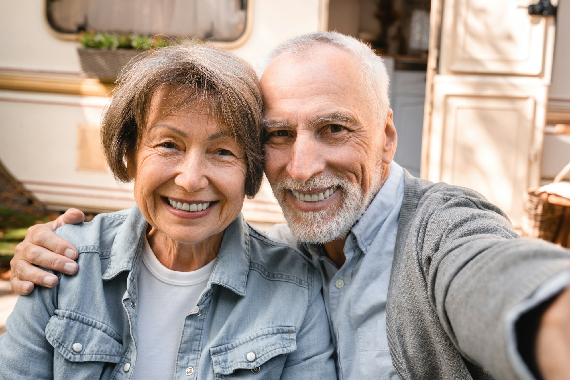 Old senior elderly couple vlogging blogging taking selfie photo in camper van trailer